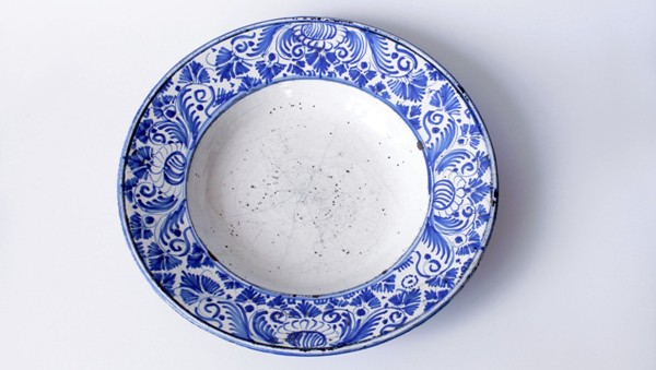 Fajánsový talíř, habánská keramika, s úzkým okrajem, bohatě zdobený kobaltovým stylizovaným rostlinným dekorem, kolem roku 1700. Zdroj: Národní muzeum