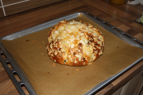 V průběhu pečení ještě jednou potřeme rozšlehaným vejcem a posypeme mandlemi.