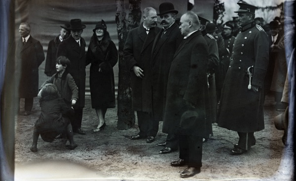 Fotografie. 1) U příležitosti položení základního kamene Národního Památníku na Vítkově si Hana Benešové oblékla plášť s bohatým kožešinovým límcem, 1928. Zdroj: Národní muzeum