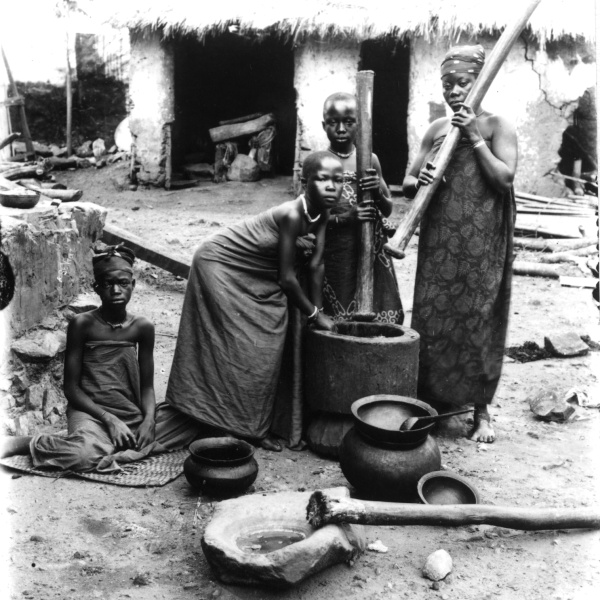 Ženy a dívky s tlouky v rukou kolem stoupy. Ghana (Zlaté pobřeží), 1885-1888. Zdroj: Národní muzeum Fotografie. Ženy a dívky s tlouky v rukou kolem stoupy. Ghana (Zlaté pobřeží), 1885-1888. Zdroj: Národní muzeum