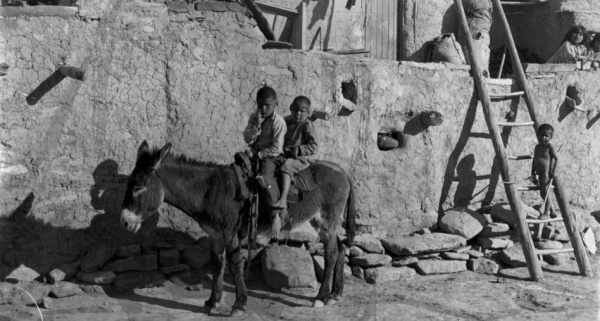 Dvě děvčátka na terase, malý chlapeček na žebříku a dva chlapci na oslíku. Hopiové z puebla Walpi. USA, Arizona, 1900. Zdroj: Národní muzeum Fotografie. Dvě děvčátka na terase, malý chlapeček na žebříku a dva chlapci na oslíku. Hopiové z puebla Walpi. USA, Arizona, 1900. Zdroj: Národní muzeum