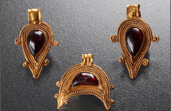 Fotografie. Zlaté půlměsícovité filigránové přívěsky se syrským granátem jsou helénistickou prací ze 2. stol. př. n. l. Foto J. Vaněk.